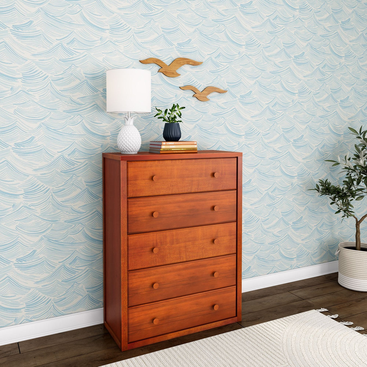 Wooden dresser with modern decor and plant against stylish wave-patterned wallpaper.