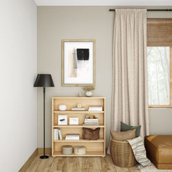 Modern living room interior with a wooden bookshelf, floor lamp, and cozy decor elements.