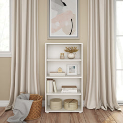 Elegant living room with a white bookshelf, decorative items, and modern art between beige curtains.