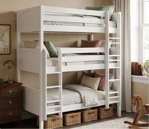 White solid wood twin-over-twin bunk bed with ladder, striped bedding and under-bed wicker storage baskets in a cozy kids' bedroom.