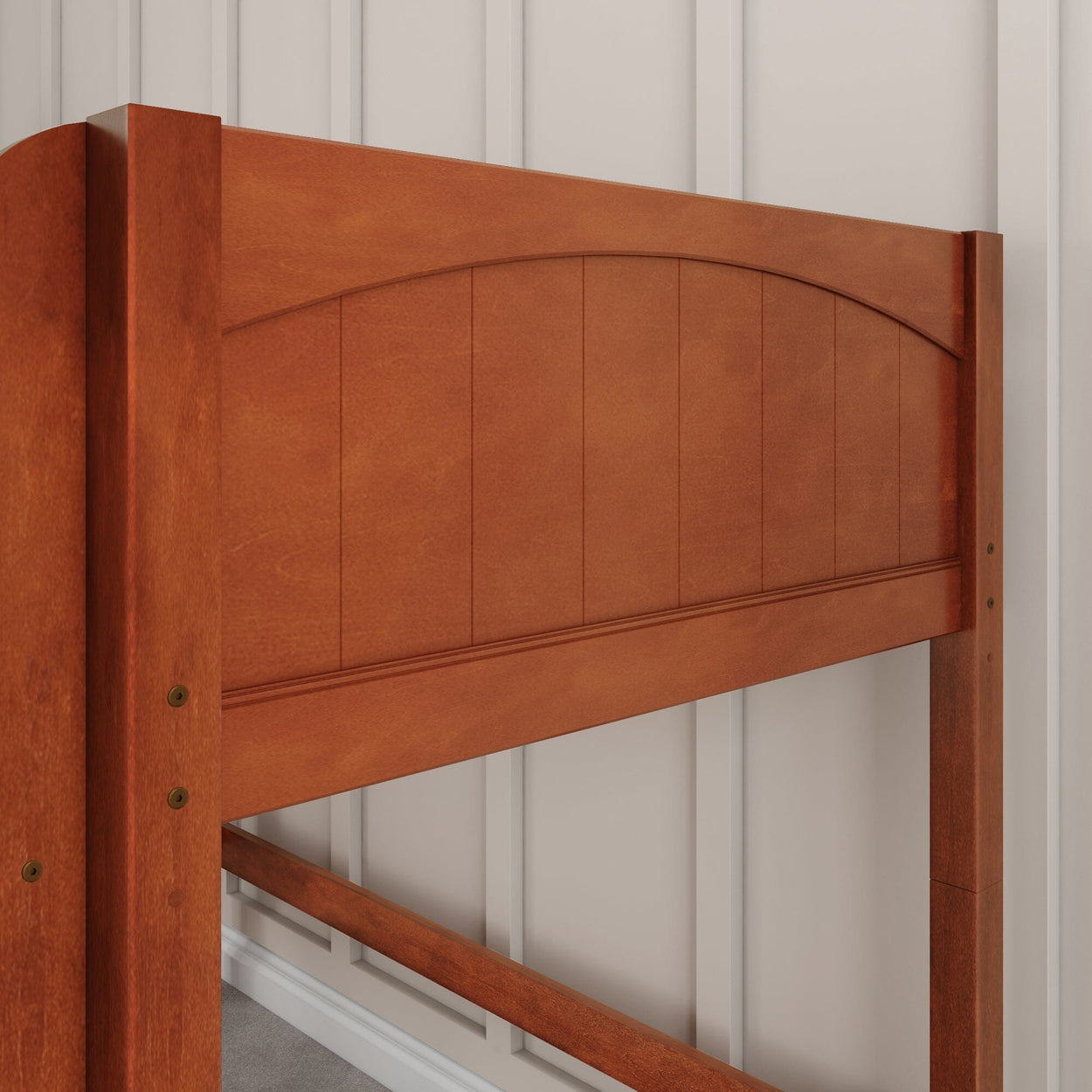 Wooden bed headboard with a natural finish against a paneled wall.