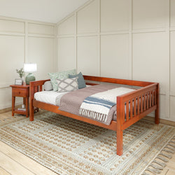 Elegant wooden daybed with cozy pillows and blanket in a serene bedroom setting, featuring a soft rug and ambient lighting.