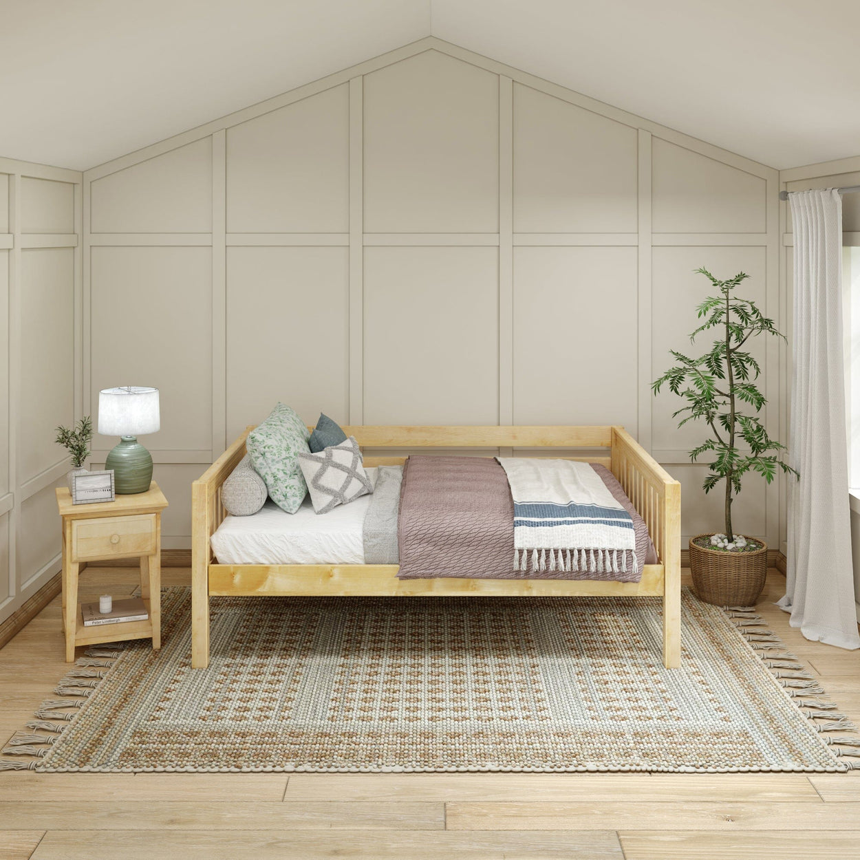 Daybed with cozy pillows and blanket in a modern bedroom with neutral decor and indoor plants.