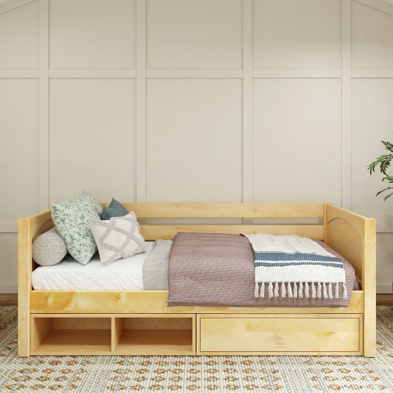 Wooden daybed with storage drawers, styled with cozy pillows and blankets in a modern bedroom setting.