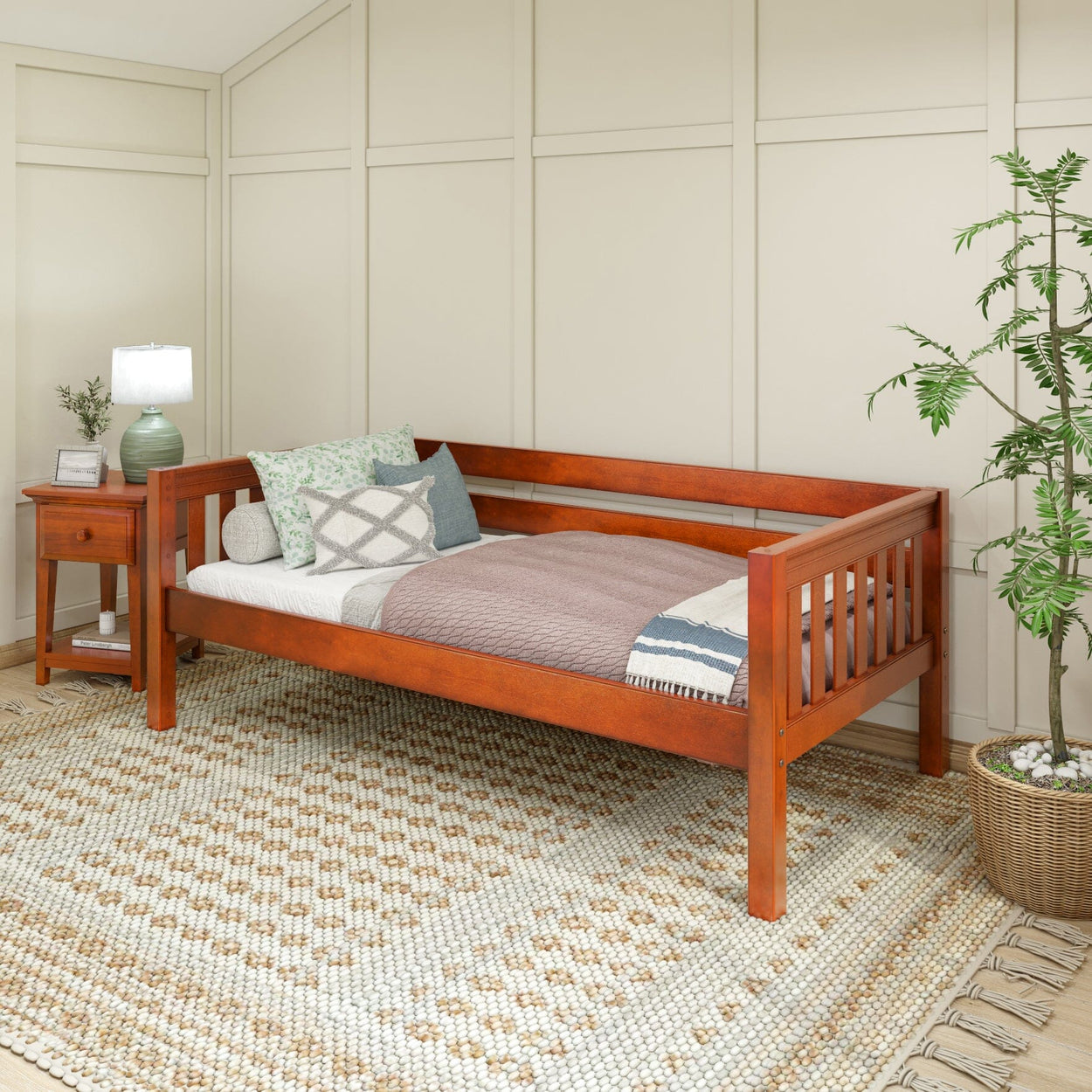Stylish wooden daybed with cozy pillows and a knit blanket in a modern bedroom setting, featuring a decorative rug and a bedside table.