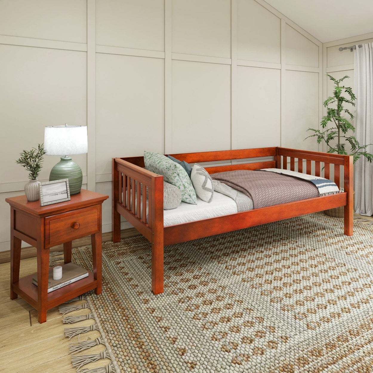Wooden daybed with side table in cozy bedroom setting featuring decorative pillows and a patterned rug.