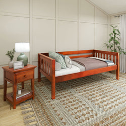 Wooden daybed with side table in cozy bedroom setting featuring decorative pillows and a patterned rug.