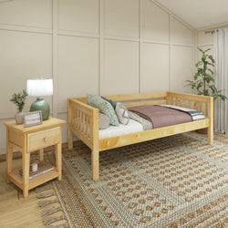 Wooden daybed in a cozy bedroom with decorative pillows, nightstand, and lamp, ideal for relaxing.