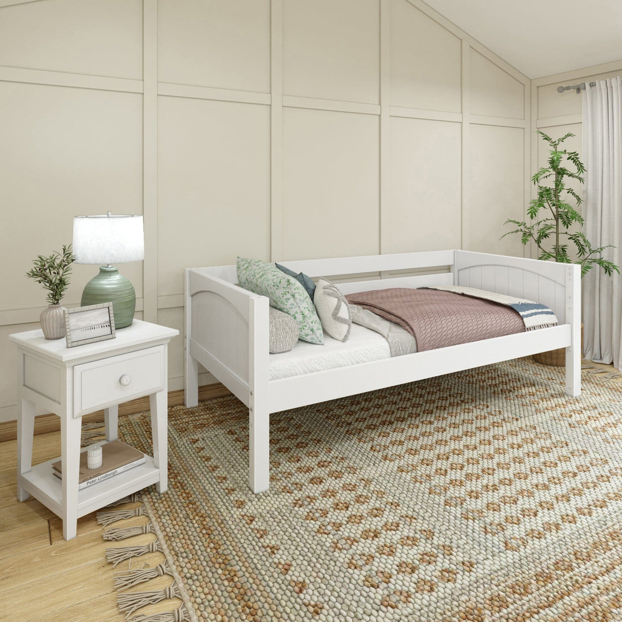 White wooden daybed with cozy bedding and a side table in a modern bedroom setting.