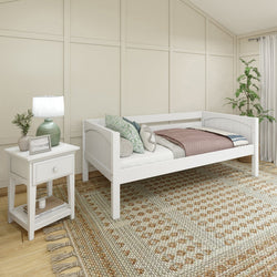 White wooden daybed with cozy bedding and a side table in a modern bedroom setting.