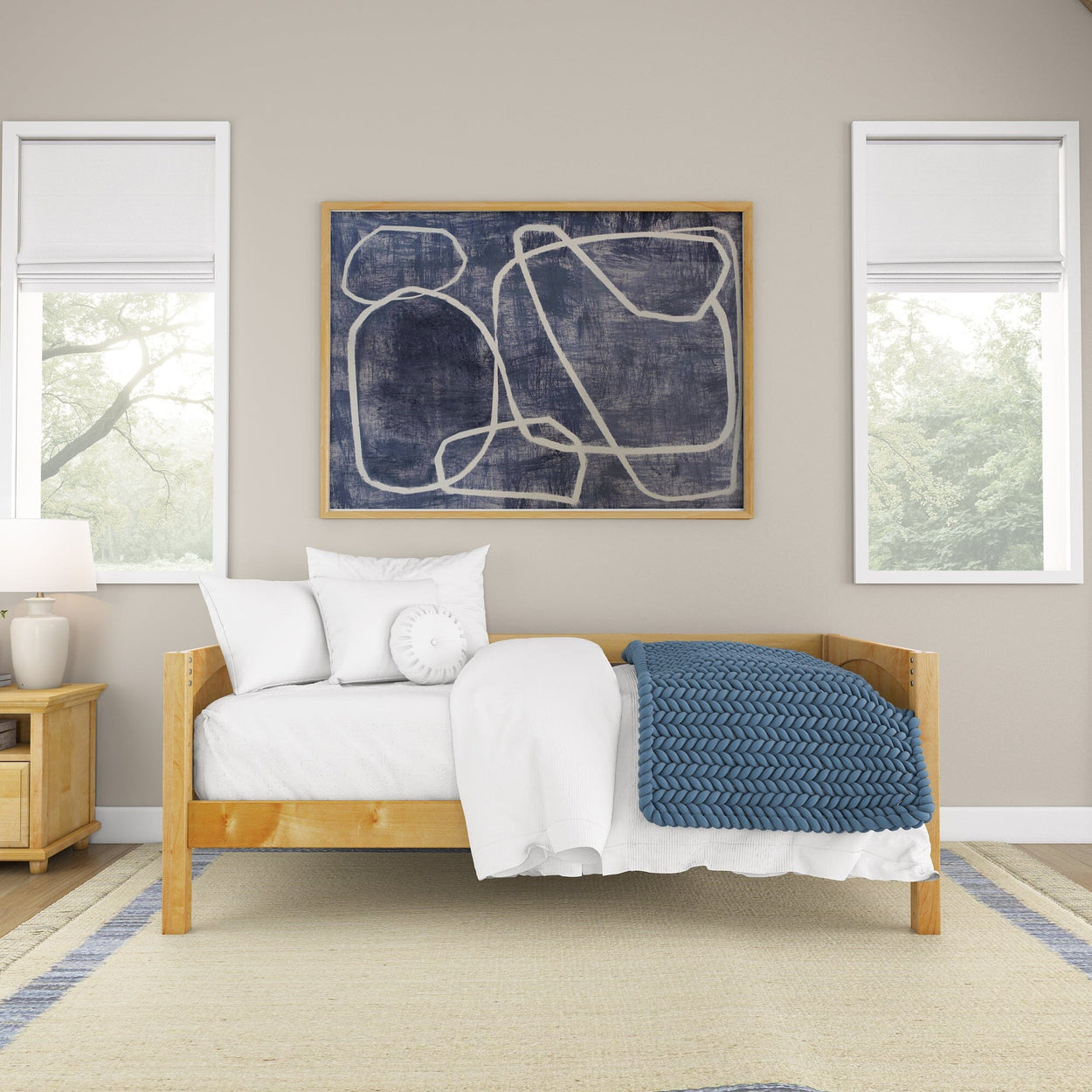 Minimalist bedroom interior with wooden bed, white and blue bedding, abstract wall art, and modern decor.