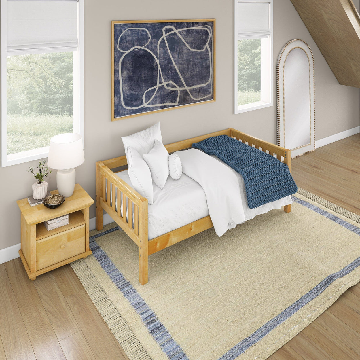 Cozy bedroom with a wooden bed, white bedding, blue blanket, bedside table, abstract wall art, and large mirror.