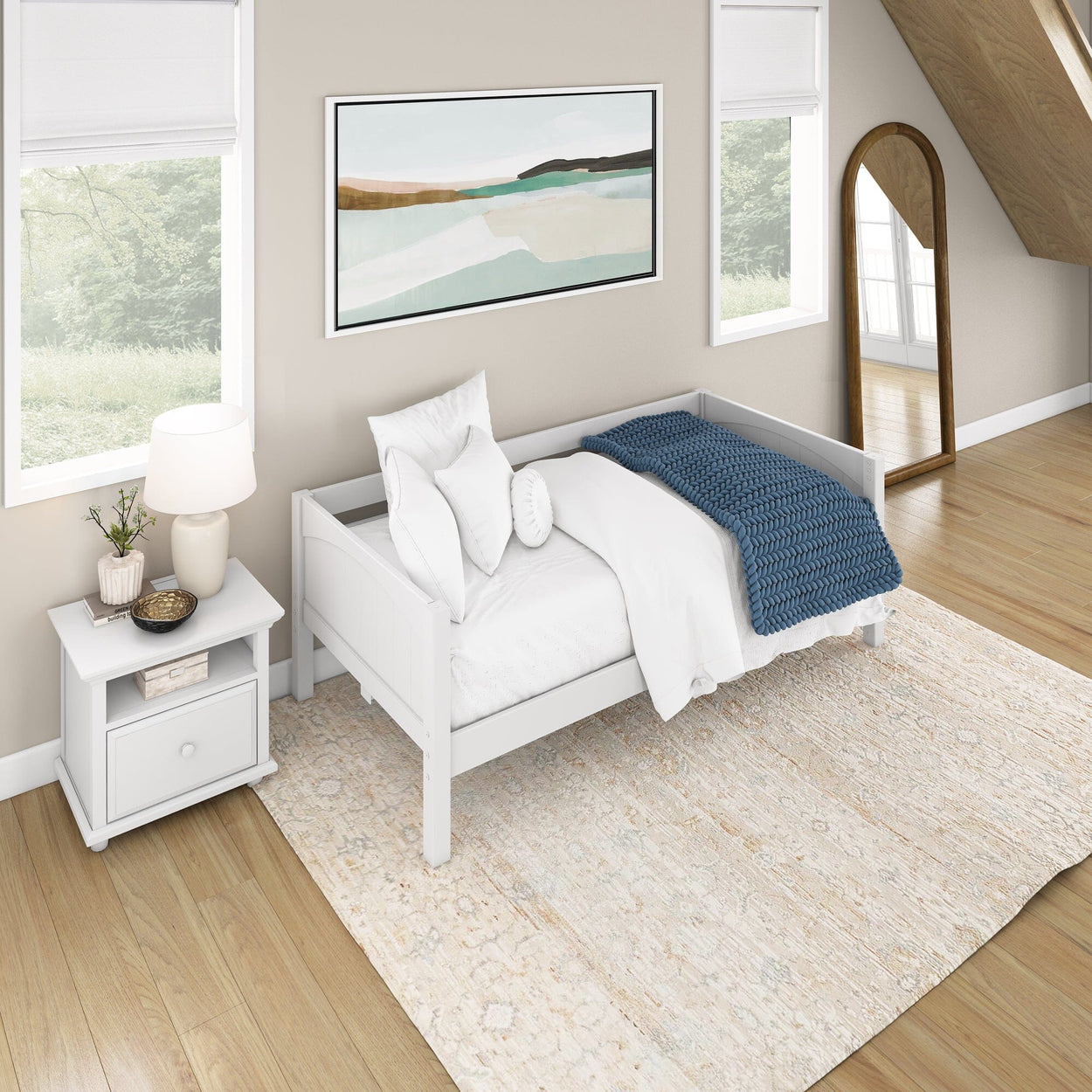 White daybed with navy blue throw in a stylish, modern bedroom with wood flooring and a large decorative mirror.