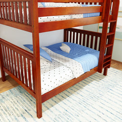 Wooden bunk bed with blue and white bedding in a bright room with a cozy rug.