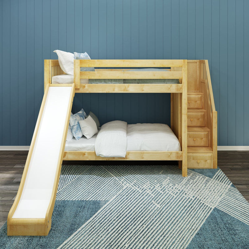 Children's natural wood bunk bed with slide and built-in stair storage drawers against blue paneled wall, white bedding and patterned blue rug