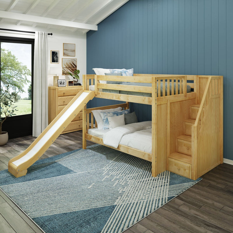 Modern children's bedroom with a natural wood bunk bed and slide, built-in storage stairs, blue paneled accent wall, light wood dresser and framed art, large window with white curtains, and a blue geometric area rug