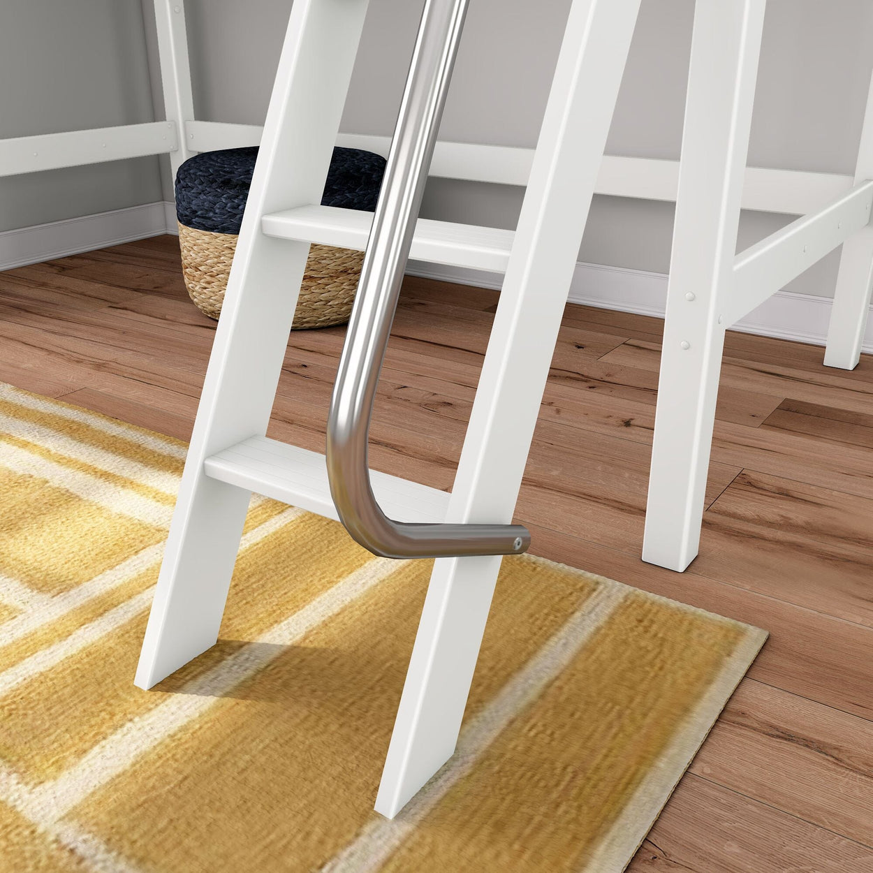 White wooden loft bed ladder with curved stainless steel handrail over yellow area rug on hardwood floor with woven storage pouf