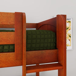 Close-up of solid cherry wood bunk bed ladder and guardrail with dark green quilted bedding and framed daisy wall art