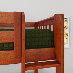 Close-up of a sturdy reddish-brown wooden bunk bed with ladder step, green quilted bedding and partial floral wall art in a children's bedroom