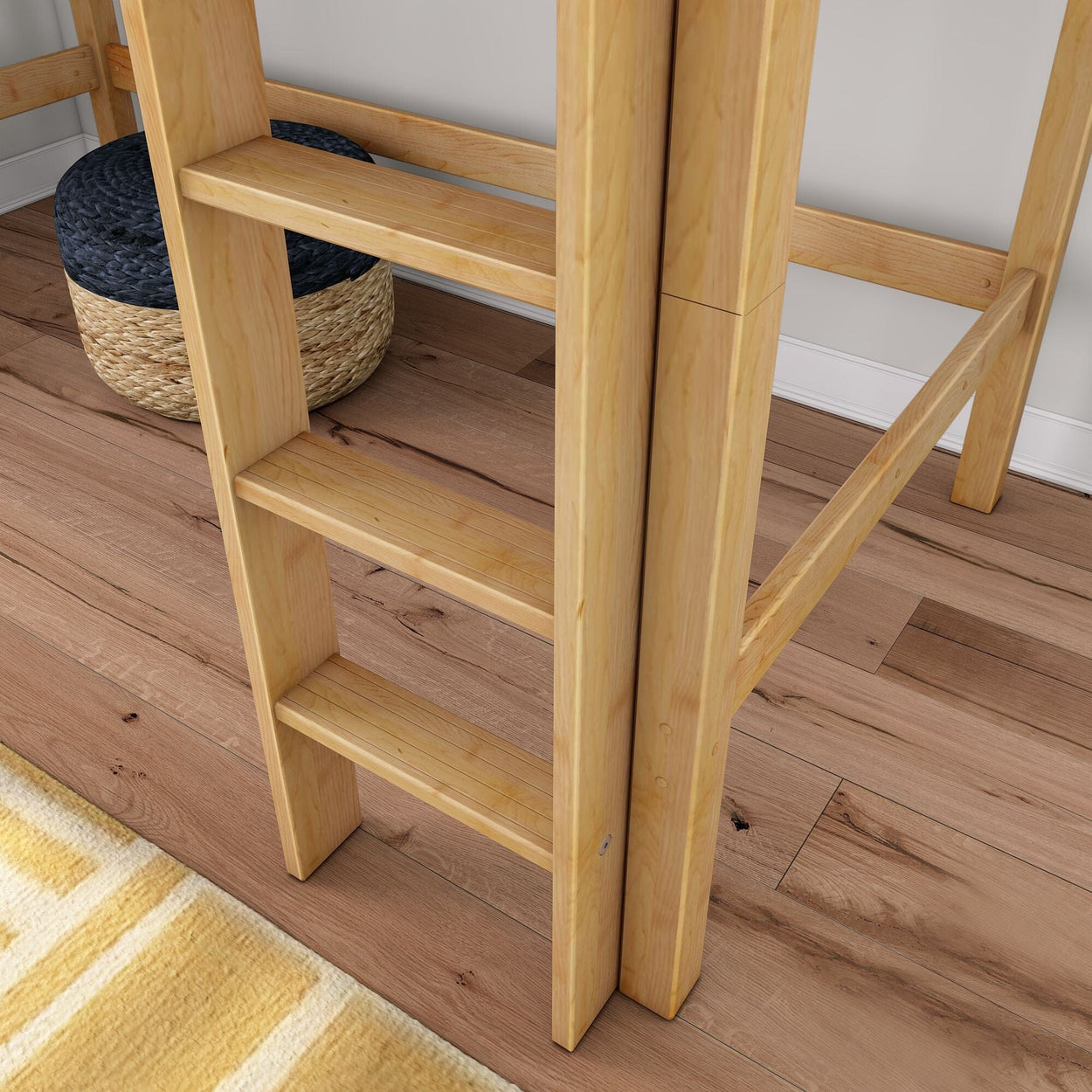 Light wooden bunk bed ladder on oak hardwood floor beside woven seagrass basket and yellow striped rug