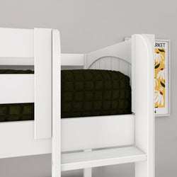 Close-up of white wooden bunk bed with dark green quilted blanket and ladder in a modern kids' bedroom featuring floral wall art