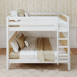 White wooden bunk bed with beige and white bedding and decorative pillows, in a stylish bedroom with chevron wallpaper.