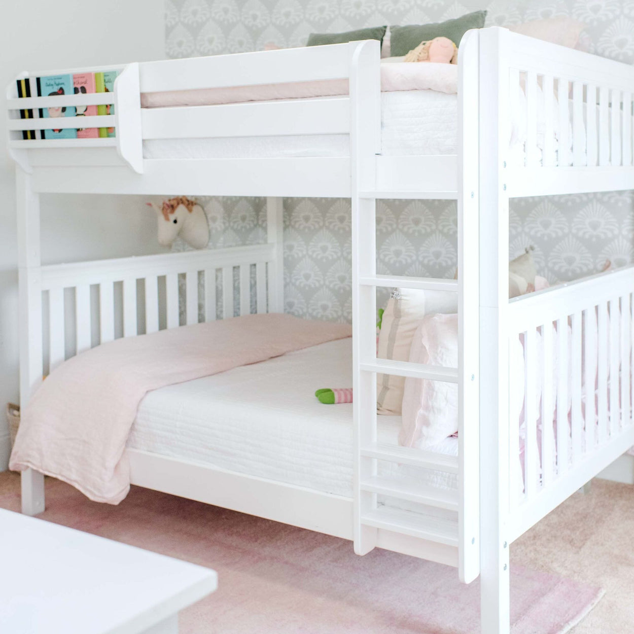 White bunk bed with pink bedding in a children's bedroom.