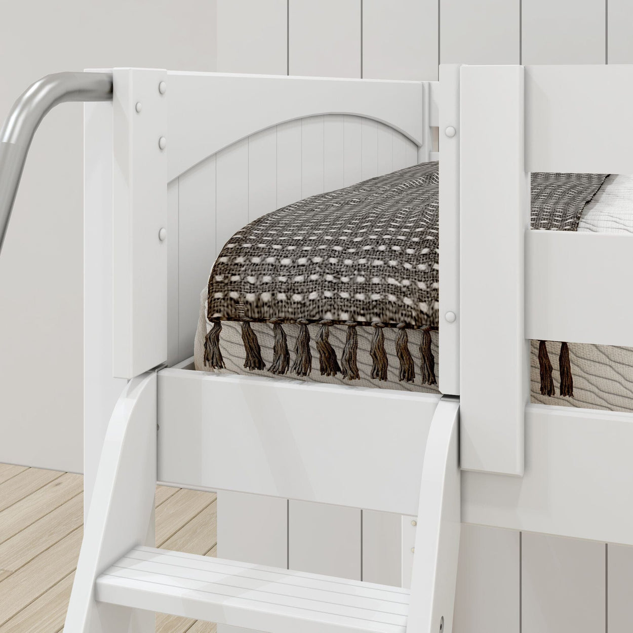 White wooden bunk bed with cozy patterned blanket on ladder side.