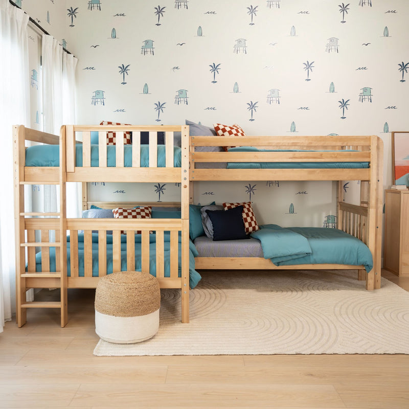 Light wood kids bunk beds with teal bedding in a coastal kids bedroom featuring beach-themed wallpaper with palm trees, surfboards, and lifeguard huts