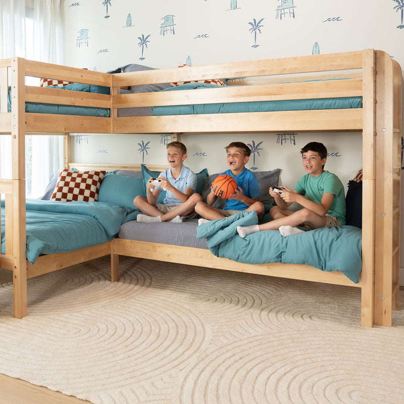 Three boys playing video games on a wooden bunk bed with teal bedding in a coastal-themed kids' bedroom