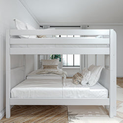White bunk bed with comfortable bedding in a bright, modern bedroom setting.