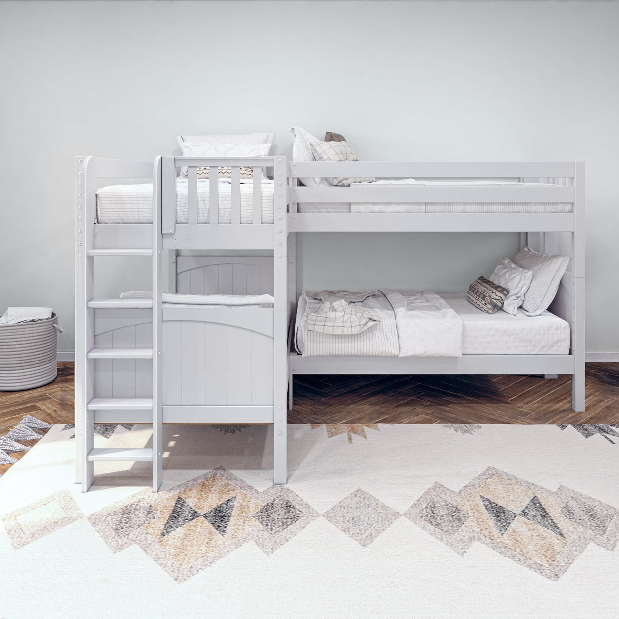 White wooden bunk bed in modern kids bedroom with cozy bedding and geometric rug.