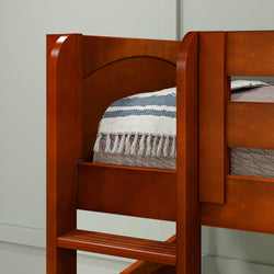 Wooden bunk bed frame with striped blanket in a cozy bedroom setting.