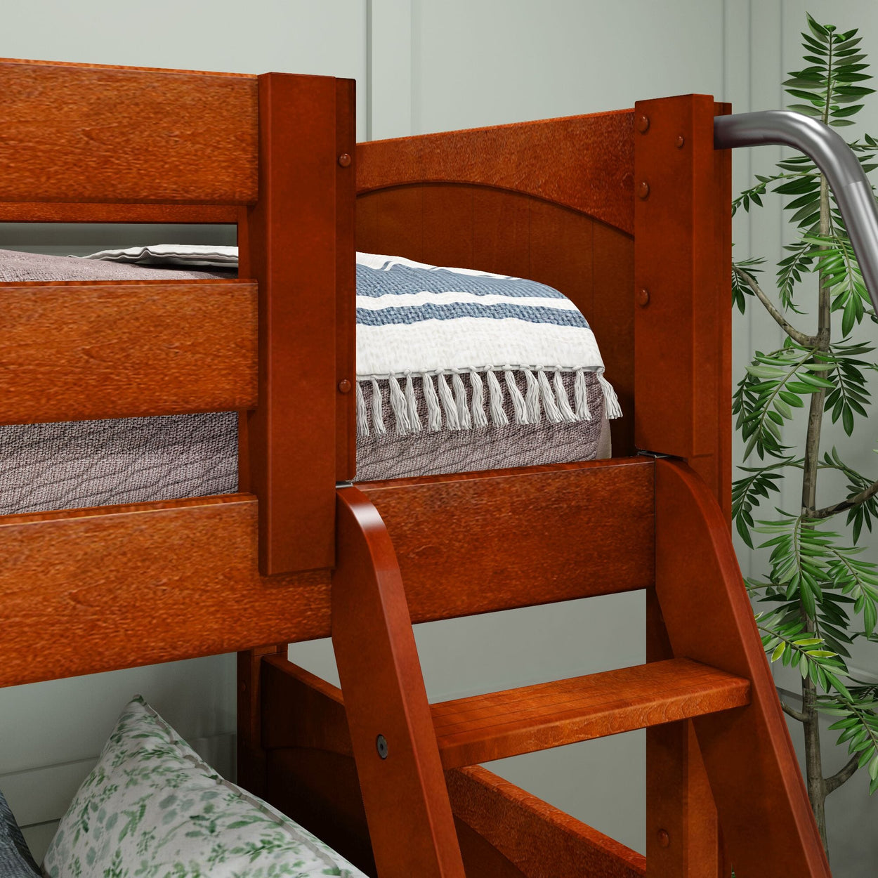 Wooden bunk bed with ladder, decorative blue and white throw blanket, and potted plant.