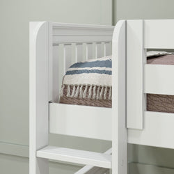 White bunk bed corner with a striped comforter and tassels in a modern bedroom.