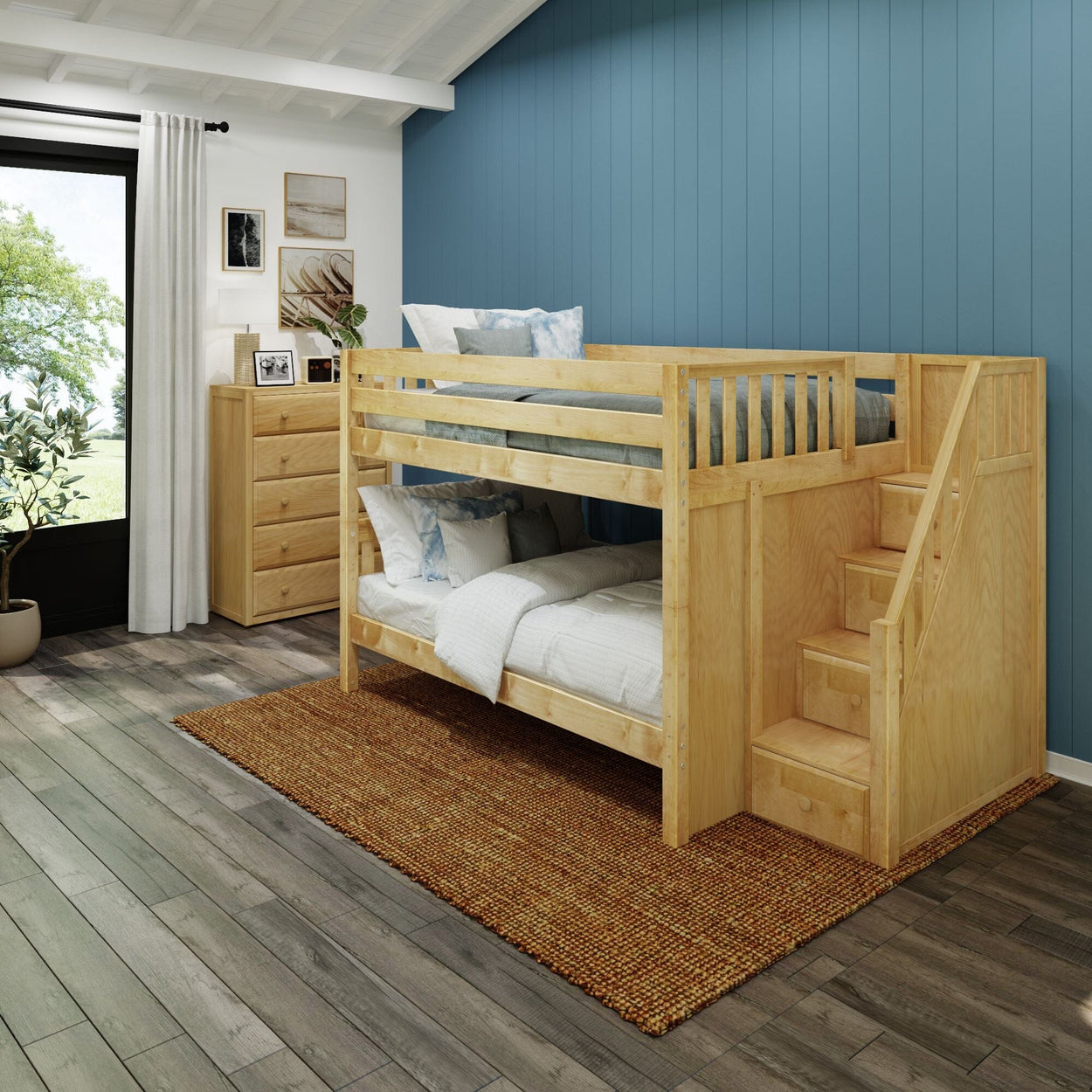 Wooden bunk bed with stairs in a modern kids' bedroom featuring blue accent wall and natural light from large window.