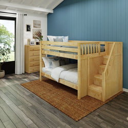 Wooden bunk bed with stairs in a modern kids' bedroom featuring blue accent wall and natural light from large window.