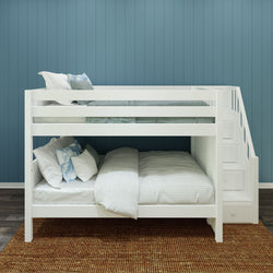 White bunk bed with built-in stairs against blue wall, featuring cozy pillows and bedding.