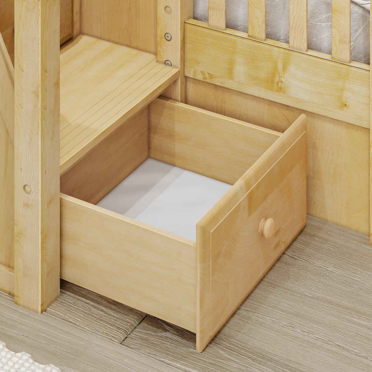 Wooden bed with open storage drawer on light wood floor.