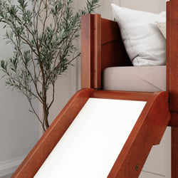 Wooden loft bed with slide and white bedding, next to a tall indoor plant in a modern bedroom setting.