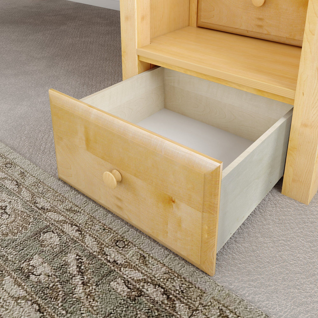Wooden dresser drawer fully extended on carpet with visible area rug.