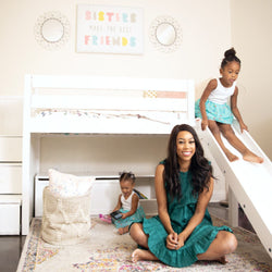 Mom and daughters in a playful bedroom with a slide and stylish decor.