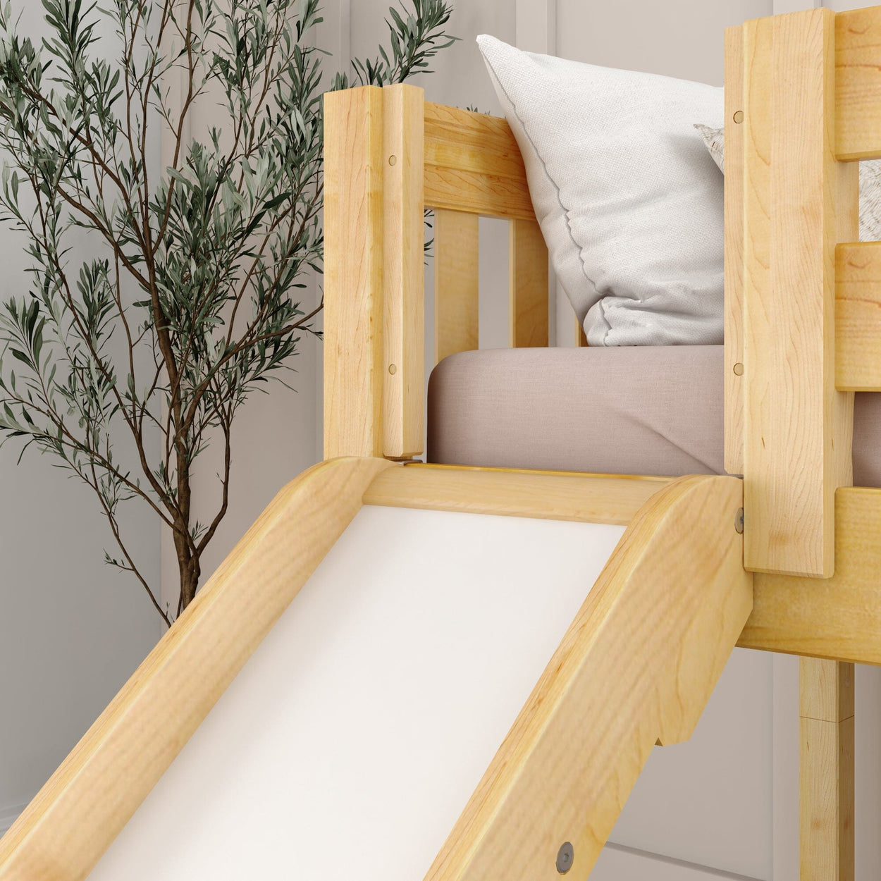 Wooden bunk bed with slide and white pillows, next to a potted plant.