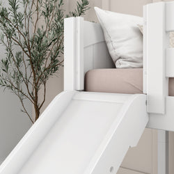 White kids' loft bed with slide and plush pillows next to a decorative potted plant.