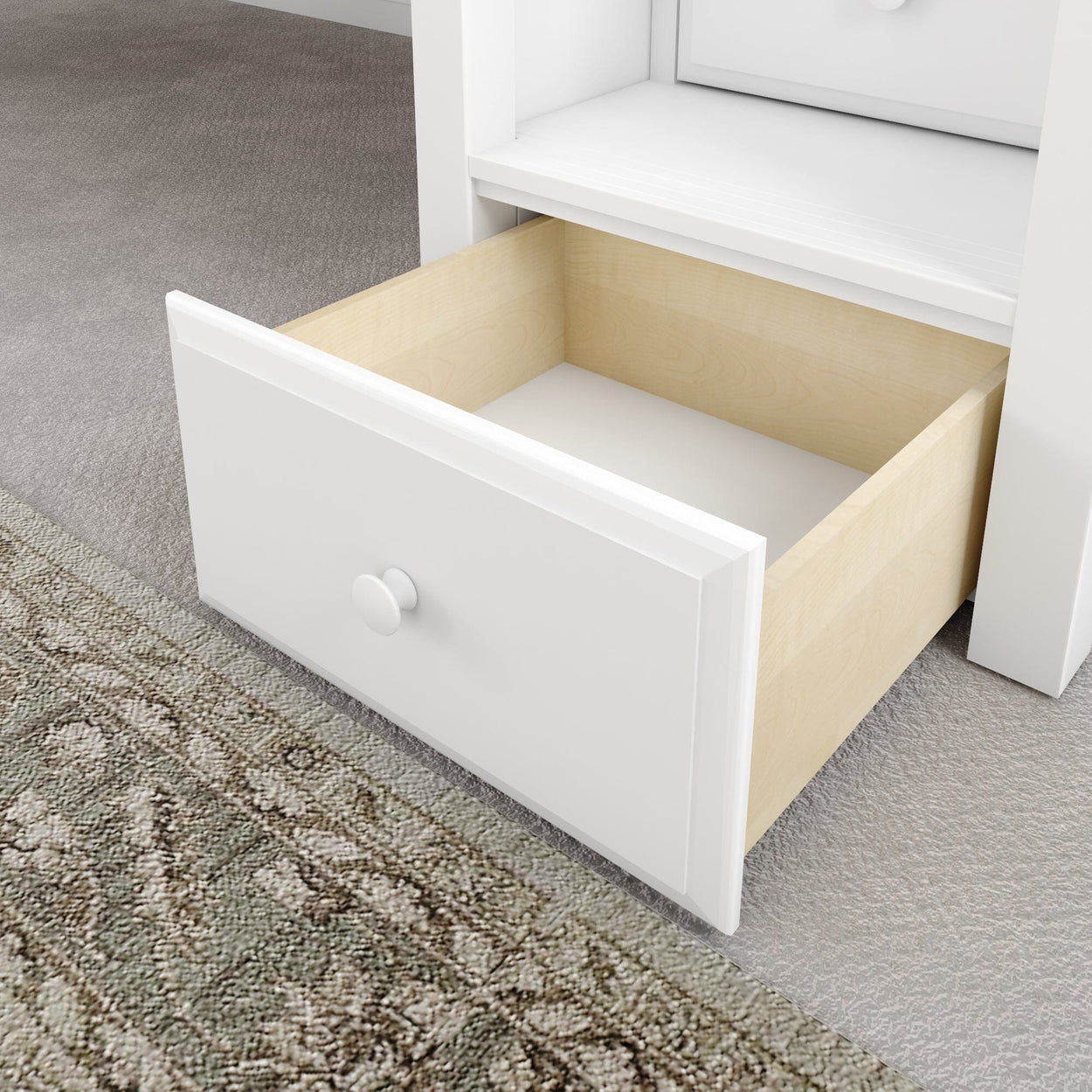 Open white drawer on a bedroom carpet floor displaying storage space.