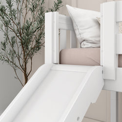 White children's bunk bed with built-in slide, cozy pillows, and indoor plant for modern bedroom decor.