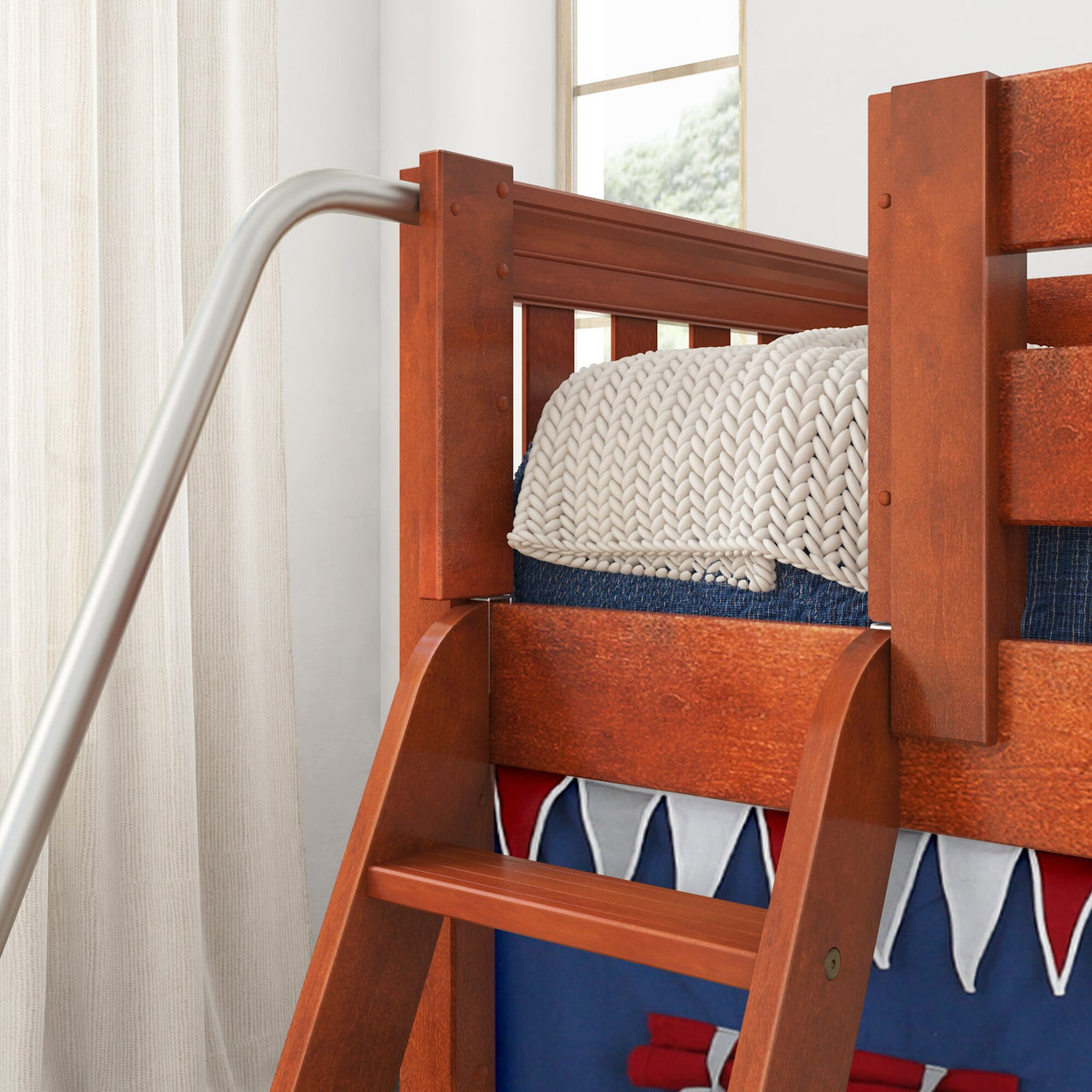 Wooden bunk bed with ladder and knitted blanket in a bright bedroom.