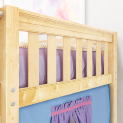 Wooden children's loft bed with safety rails and colorful fabric curtains.