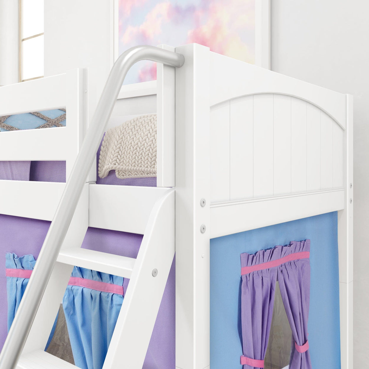 White loft bed with purple and blue curtains, featuring a ladder and cozy knitted blanket, perfect for children's bedroom decor.