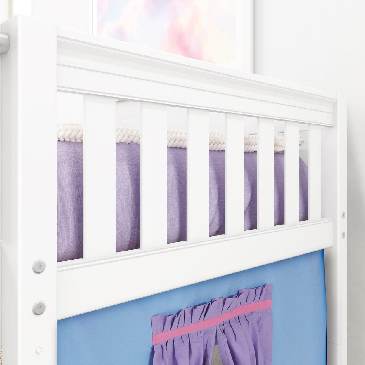 White convertible toddler bed with purple and blue bedding.